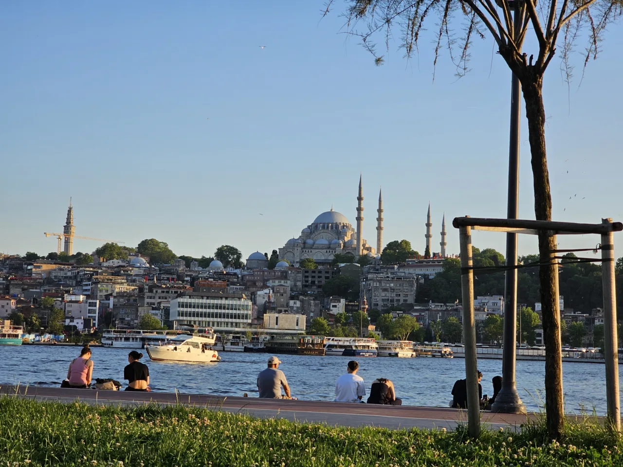 Paseo arbolado junto al Cuerno de Oro, con Süleymaniye al otro lado del agua.