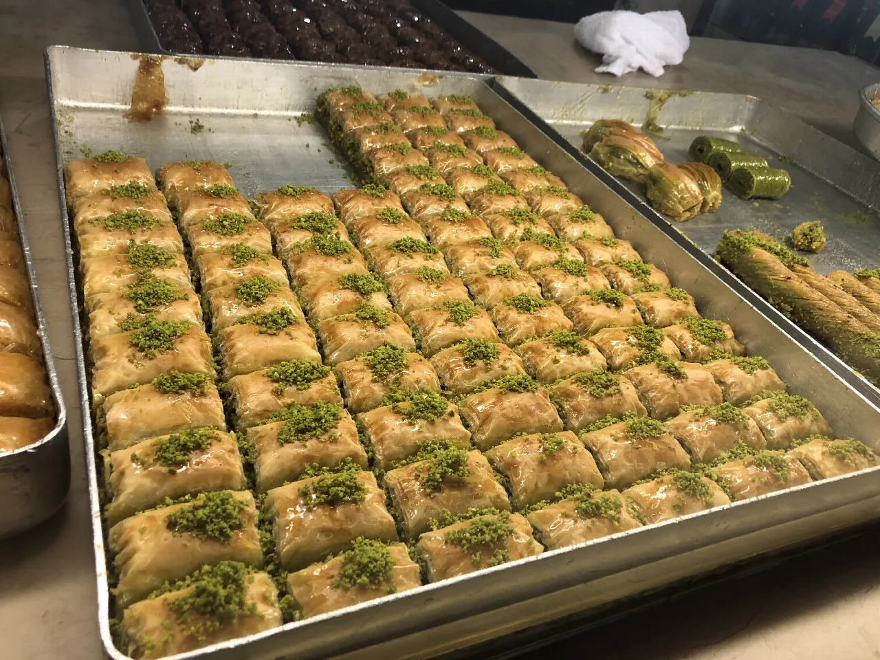 Bandeja de baklava de pistacho en una vitrina de pastelería.