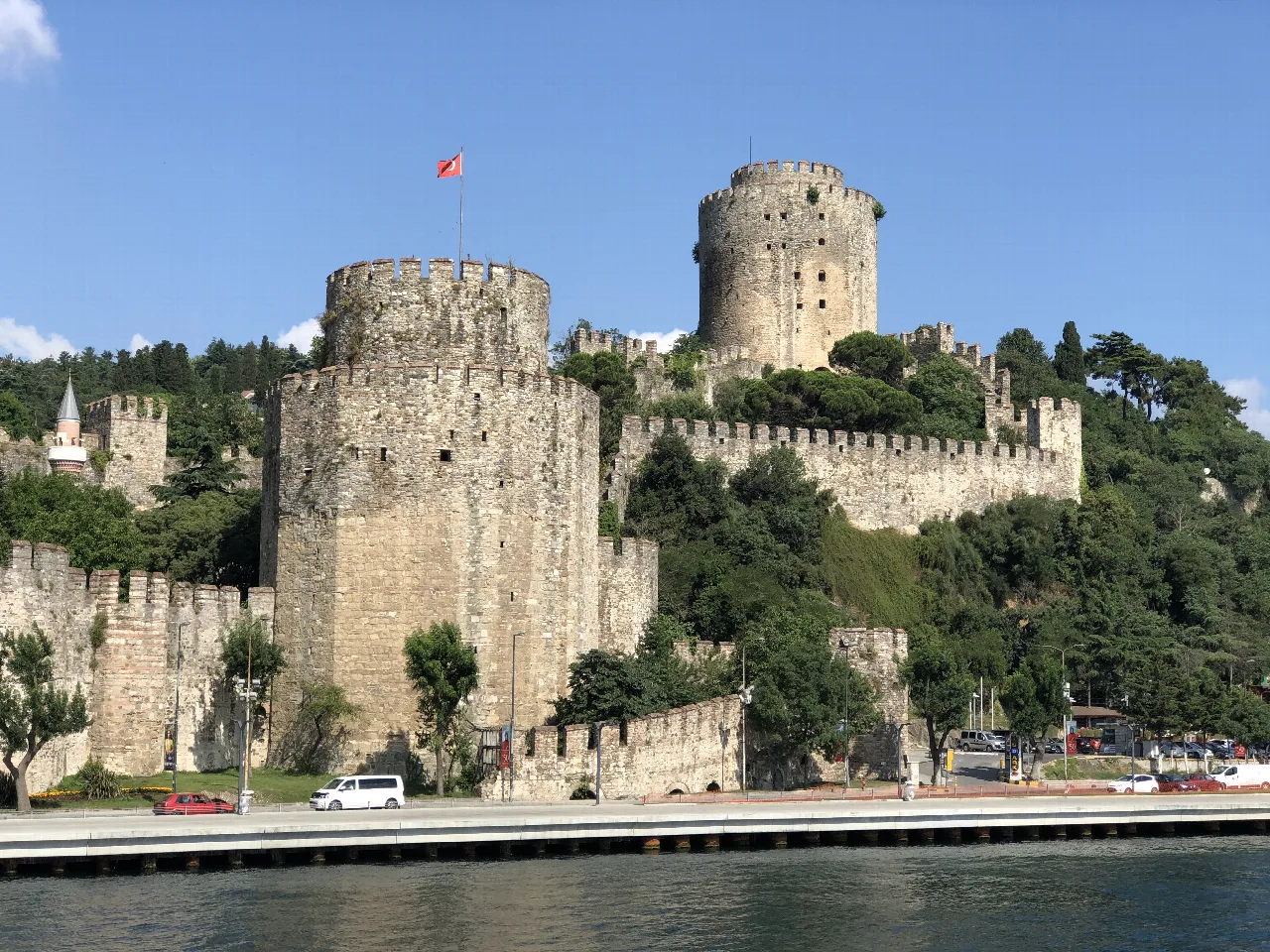 Torres y murallas de la fortaleza de Rumeli Hisarı junto a árboles.