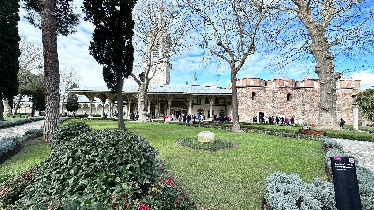 Patio de Topkapı con árboles, arcos y la Torre de la Justicia.